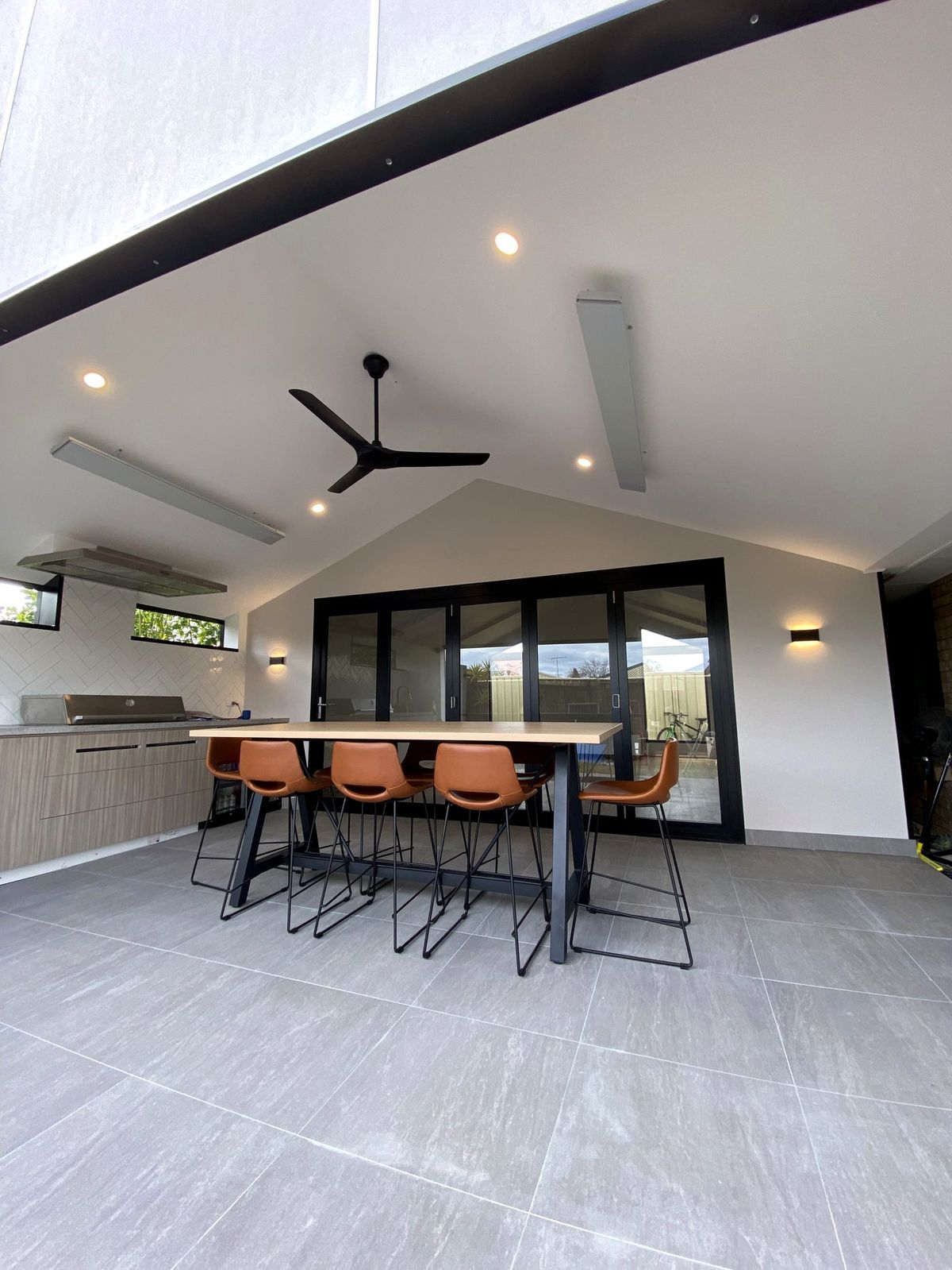 Outdoor alfresco area with a ceiling fan, downlights and wall lights installed