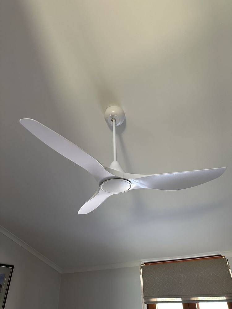 A three-blade ceiling fan installed on a white ceiling