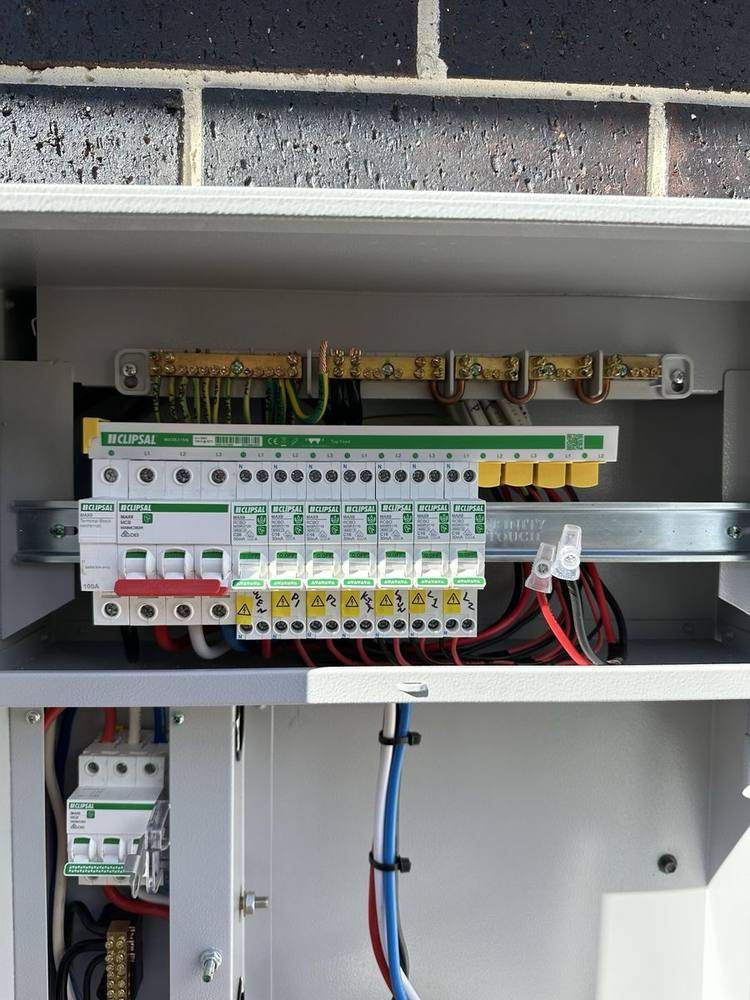 A labelled residential switchboard with safety switches, cover removed for testing